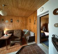 Családi ház belső tere fa burkolattal és kényelmes bútorokkal, retro dekorációkkal.