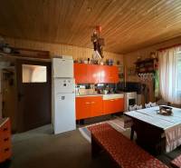 Konyha családi házban antik bútorokkal, rusztikus fal, nagy ablak.