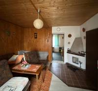 Nappali egy családi házban, fa dekorációval a falakon és a mennyezeten.