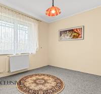 Szoba egy családi házban világos szőnyeggel, függönyökkel és fali képpel.