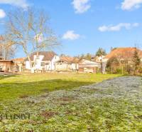 Kert a családi ház mellett a Nemečkovská utcán, Prašiceben, fákkal és gyepes területtel.