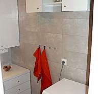 Fürdőszoba mosógéppel és tárolóhellyel egy 4 szobás lakásban.