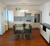 Négyszobás lakás konyhája étkezőasztallal és fa dekorációjú padlóval.