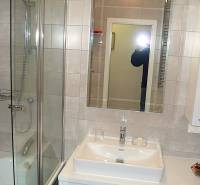 Fürdőszoba zuhanyzóval, tükörrel és mosdóval egy 4 szobás lakásban.
