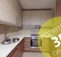 Konyha egy kétszobás lakásban fa dekor padlóval és beépített szekrényekkel.