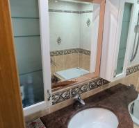 Fürdőszoba beépített szekrénnyel és tükörrel egy háromszobás lakásban.