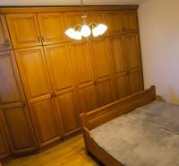 Hálószoba egy háromszobás lakásban nagy gardróbszekrénnyel és ággyal.