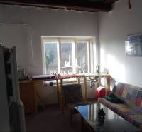 Nappali kanapéval és kilátással kifelé, Családi ház egyszerű berendezéssel.