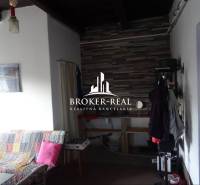 Családi ház belső tere kanapéval és fogassal, háttérben burkolt fal.