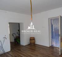 Nappali tér egy családi házban fa dekorációjú padlóval és fehér falakkal.