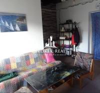 Nappali egy családi házban színes kanapéval, dohányzóasztallal és fali képpel.