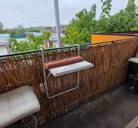 Egy galántai 3 szobás lakás erkélye modern korláttal és fehér bárszékekkel.