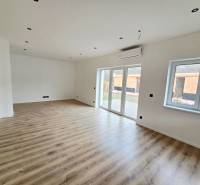 Családi ház belső tere fa dekorációjú padlóval és nagy ablakokkal.