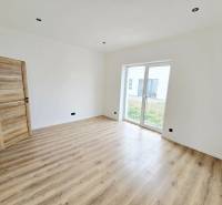 Családi ház belső tere fa dekor padlóval és nagy ablakkal a kertre.