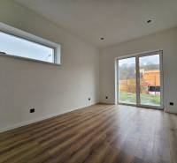 Családi ház belső tere fa dekorációjú padlóval és nagy ablakkal.