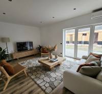 Nappali egy családi házban, fapadlóval és elegáns bútorokkal.