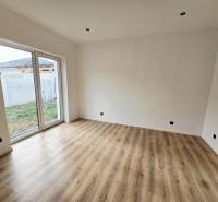 Szoba családi házban üvegajtókkal és fa mintázatú padlóval.