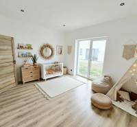 Gyerekszoba családi házban, fa dekoros padlóval és boho dekorációkkal.