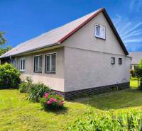 Családi ház Nyitrán fehér homlokzattal és zöldellő kerttel.