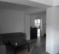 Nappali szürke kanapékkal, asztallal és csempézett padlóval a raktárakban és csarnokokban.