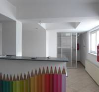 Raktárak és csarnokok belső tere recepciós pulttal, amelyet színes ceruzák és tűzcsap díszít.