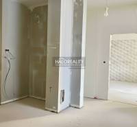 Családi ház befejezetlen felújítása feltárt falakkal és lépcsőnyílással.