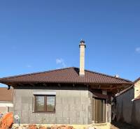 Családi ház építés alatt Cíferen, barna tetővel és kéménnyel.