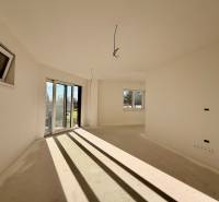 Tágas szoba egy családi házban nagy ablakokkal és kertre néző kilátással.