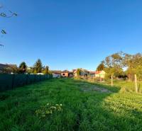 Fűvel borított és kerítéssel körülvett telek Cíferen, családi házak közelében.