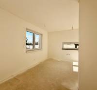 Üres szoba dupla ablakkal és betonpadlóval egy családi házban.