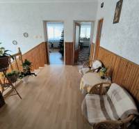 Családi ház belső tere lépcsőházzal, fa dekorációjú padlóval és tágas előszobával.