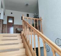 Családi ház fa lépcsővel, falburkolattal és dekorációval.