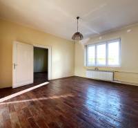 Szoba egy 5 vagy több szobás lakásban, fa mintázatú padlóval és nagy ablakokkal.