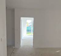 Családi ház világos szobával, fehér falakkal és nagy ablakokkal a kertre.