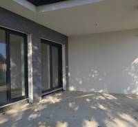 Egy családi ház terasza Pöstyénben nagy ablakokkal és kő dekorációval.