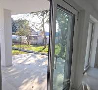 A családi ház teraszra vezető ablakai és ajtói, kilátás a kertre.