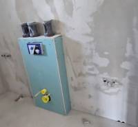 Családi ház befejezetlen fürdőszobája, falba előkészített szereléssel.