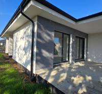 Családi ház Pöstyénben terasszal és kerttel, amelyet zöld kerítés határol.