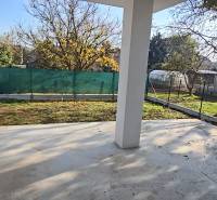 Családi ház Pöstyénben kerttel, bekerített udvar gyeppel és fákkal a telken.