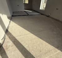 Családi ház belső tere betonpadlóval és nagy ablakokkal Pozsony mellett.