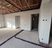 Családi ház belső tere építés alatt álló falakkal és fa dekorációjú padlóval.