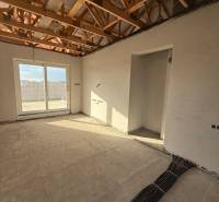 Családi ház belső tere látszó mennyezeti gerendákkal és elektromos szerelés előkészítésével.