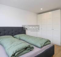 Hálószoba franciaággyal, beépített szekrényekkel és fa dekorációjú padlóval egy kétszobás lakásban.