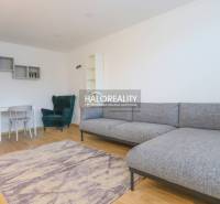 Nappali egy kétszobás lakásban sarokkanapéval és fa dekorációjú padlóval.