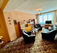 Nappali egy kétszobás lakásban kanapéval és üveges vitrinnel.