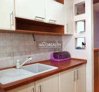 Konyhasarok a garzonlakásban mosogatóval és szekrényekkel.