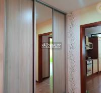 Garzonlakás konyhával, fa burkolattal és beépített szekrénnyel.