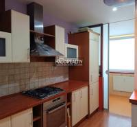 Garzonlakás konyhája gáztűzhellyel és üvegszekrényekkel.