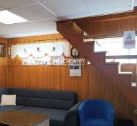 A faház belső tere fa burkolattal, lépcsőkkel, kanapéval és fali dekorációkkal.