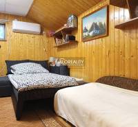 Szoba faházban fa burkolatú falakkal és kényelmes ággyal.